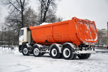 Photo for Snow removal from the city streets is heavily loaded with transport - Royalty Free Image