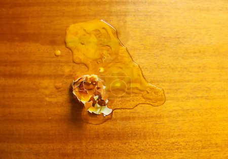 Photo for "Raw smashed egg on wooden table." - Royalty Free Image