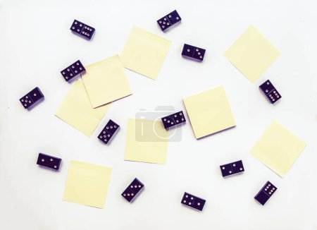 Foto de "Montón de azulejos de dominó negro vintage y notas adhesivas sobre fondo claro." - Imagen libre de derechos