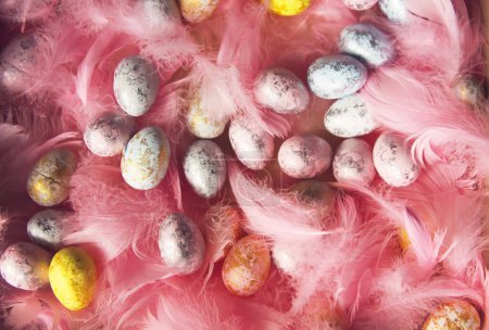 Foto de "Composición de Pascua con decoración tradicional de pequeños huevos de colores y plumas suaves." - Imagen libre de derechos