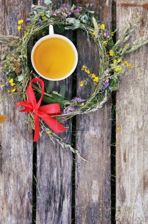 Foto de "Herbal tea of medical plants in a cup outdoors on old weathered boards" - Imagen libre de derechos