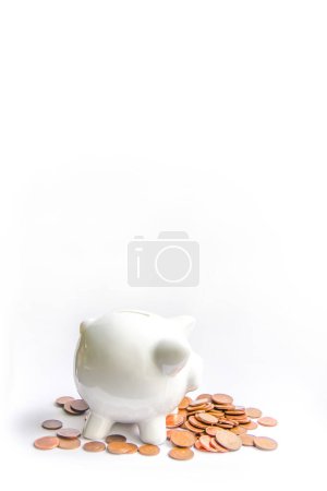 Foto de "Piggy bank with coins. White ceramic moneybox." - Imagen libre de derechos