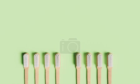 Téléchargez les photos : Brosses à dents en bois bio sur fond vert - en image libre de droit