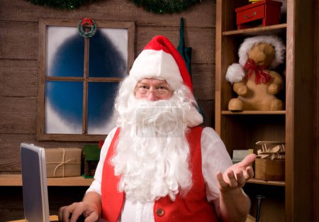 Téléchargez les photos : Père Noël en atelier avec ordinateur portable - en image libre de droit