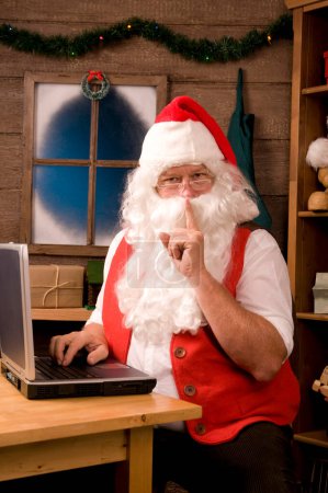 Foto de Santa Claus en el taller usando el ordenador portátil - Imagen libre de derechos