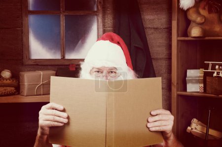 Téléchargez les photos : Père Noël lecture grand livre - en image libre de droit