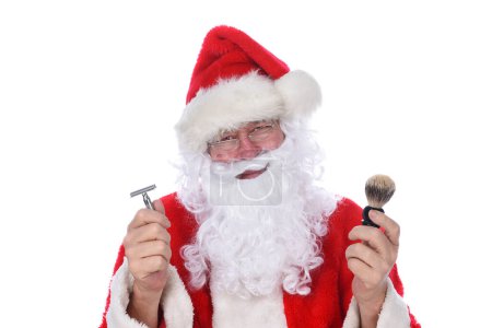 Foto de Primer plano de Santa Claus sosteniendo una navaja y un cepillo de afeitar, contemplando cortarle la barba. - Imagen libre de derechos