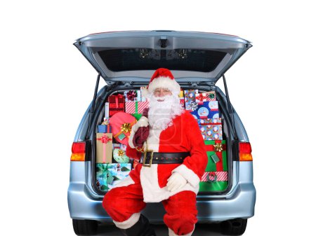 Foto de Santa Claus sentado en una minivan con su puerta trasera abierta y llena de regalos de Navidad envueltos. Aislado sobre blanco. - Imagen libre de derechos