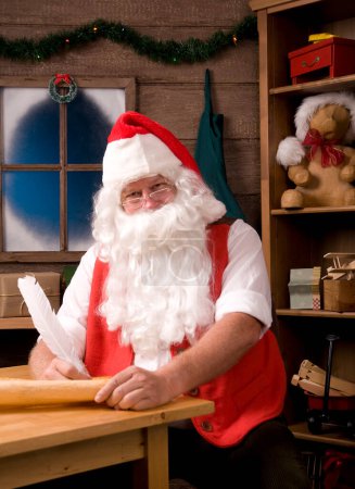 Foto de Santa Claus sentado en su taller con pluma de pluma - Imagen libre de derechos