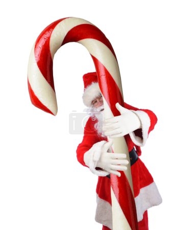 Photo for Man is traditional Santa Claus costume with his arms wrapped around a huge Candy Cane. - Royalty Free Image