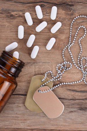 Photo for Military and Veterans Health Care Concept. Dog tags and pills on a wood background. - Royalty Free Image
