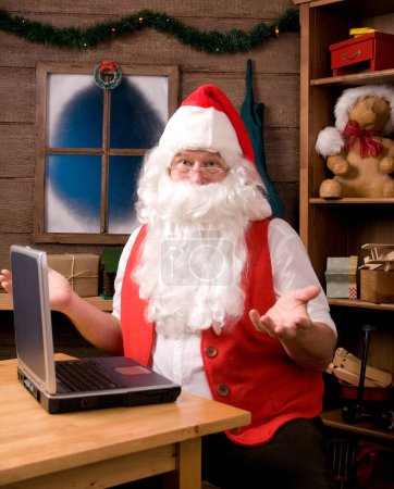 Foto de Santa Claus en el taller con el ordenador portátil - Imagen libre de derechos