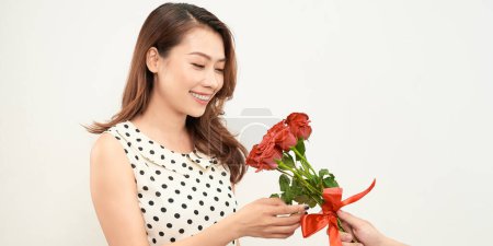 Foto de "Bastante asiático sorprendido con un ramo de rosas rojas" - Imagen libre de derechos