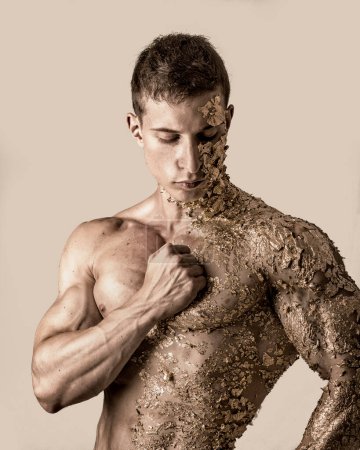 Téléchargez les photos : "Jeune homme musclé couvert de taches d'or" - en image libre de droit