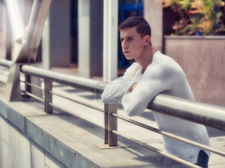 Foto de "Musculoso joven con camisa blanca en el entorno de la ciudad" - Imagen libre de derechos