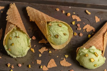 Téléchargez les photos : "Crème glacée aux pistaches dans des cônes de gaufres
 " - en image libre de droit