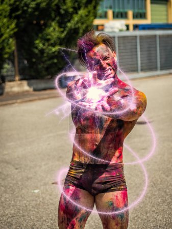 Foto de "Guapo hombre sin camisa tatuado sosteniendo la ilusión de luz de energía azul en su mano" - Imagen libre de derechos