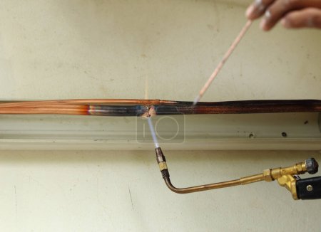Foto de "Aire acondicionado reparador soldadura tubos de cobre
" - Imagen libre de derechos
