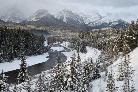 Téléchargez les photos : Rivière à travers les montagnes enneigées en hiver - en image libre de droit