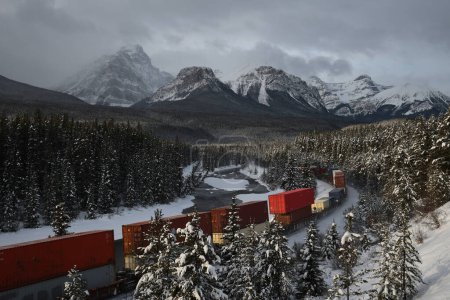 Foto de Paisaje de tren moviéndose a través de montañas nevadas en invierno - Imagen libre de derechos