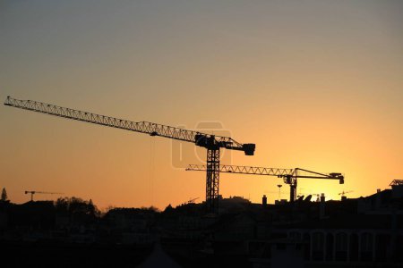 Téléchargez les photos : Cranes working at sunset in Lisbon - en image libre de droit