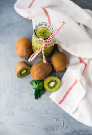 Téléchargez les photos : Gros plan du smoothie au kiwi bio frais sur la table pour le fond - en image libre de droit