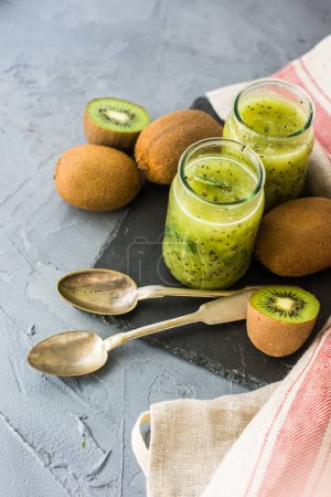 Téléchargez les photos : Gros plan du smoothie au kiwi bio frais sur la table pour le fond - en image libre de droit