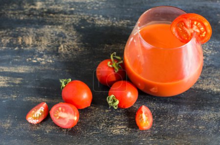 Foto de Jugo de tomates sobre fondo rústico - Imagen libre de derechos