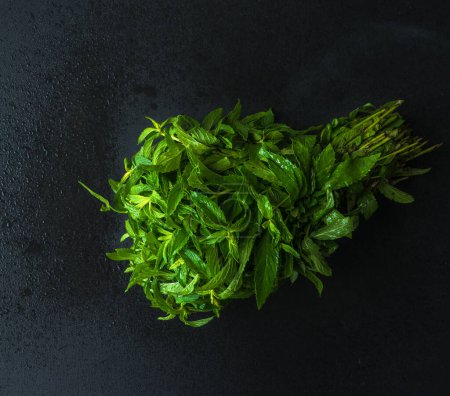 Téléchargez les photos : Gros plan du bouquet de basilic bio frais sur la table pour le fond - en image libre de droit