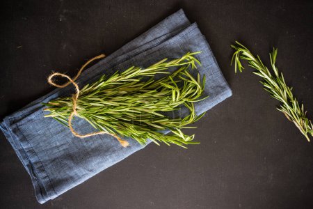 Photo for Close-up shot of fresh organic branches of rosemary on tabletop for background - Royalty Free Image