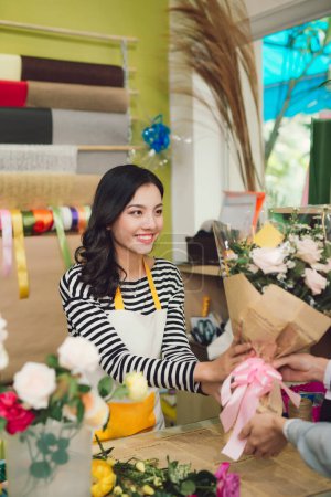 Téléchargez les photos : "Femme vendant des fleurs à un homme
" - en image libre de droit