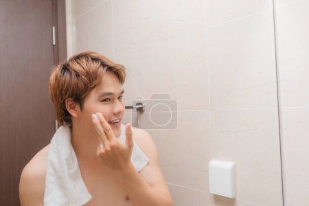 Téléchargez les photos : "bel homme lavage visage dans salle de bain
" - en image libre de droit