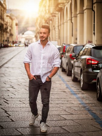 Photo for "Young man in European city street walking" - Royalty Free Image