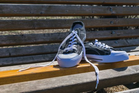 Foto de Nuevas zapatillas deportivas en un banco del parque en verano - Imagen libre de derechos