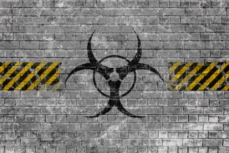 Téléchargez les photos : "Faded biohazard sign with yellow black lines on brick wall" - en image libre de droit