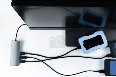 Foto de Adaptador con conexión de discos duros externos conectados a un monobloque sobre fondo blanco. Ordenador con disco duro - Imagen libre de derechos
