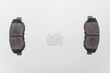 Photo for "Two brake pads on the edges of the table, parts for car repair." - Royalty Free Image