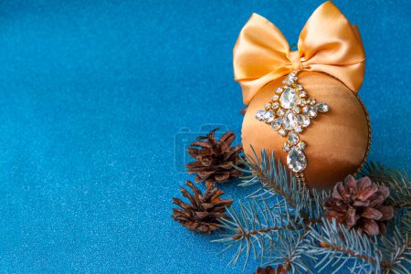 Foto de "Bola de Navidad de oro en diamantes de imitación para la decoración del árbol de Navidad. Juguete de Navidad. Bola de Navidad para la decoración del árbol de Navidad sobre fondo azul." - Imagen libre de derechos