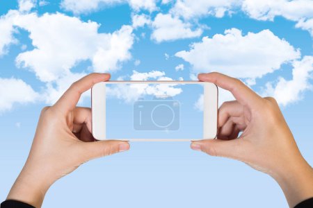Téléchargez les photos : Deux mains tenant smartphone grand écran sur fond de ciel - en image libre de droit