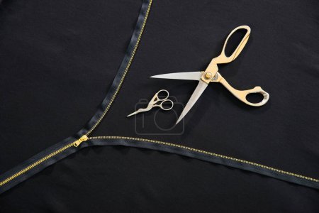 Photo for Tailor background with open golden zipper and two scissors in atelier studio - Royalty Free Image