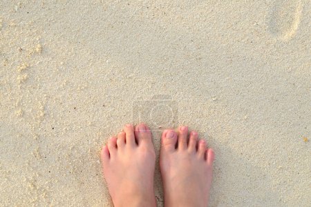 Téléchargez les photos : Pieds de fille dans le sable sur la plage - en image libre de droit