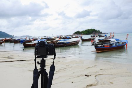 Téléchargez les photos : Appareil photo prendre des bateaux de pêche photo sur la plage - en image libre de droit