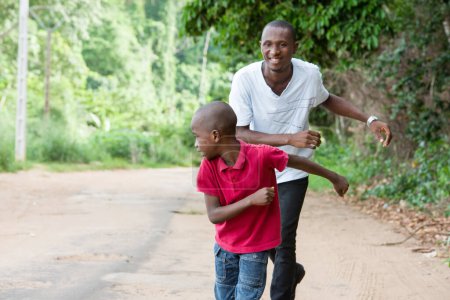 Téléchargez les photos : Père et fils s'amusent à courir dehors - en image libre de droit