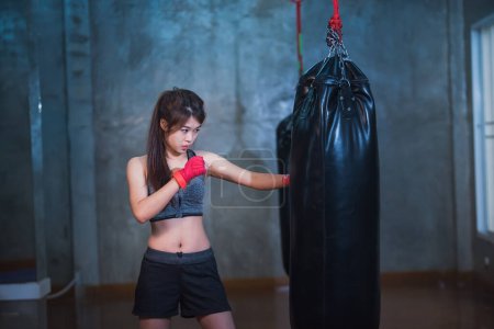 Téléchargez les photos : Sexy asiatique fille punching boxe sac - en image libre de droit