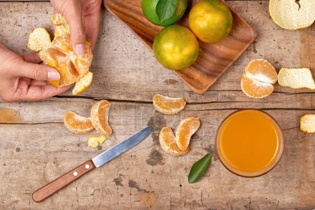 Photo for Glass of tangerine juice and fresh peeled fruits - Royalty Free Image