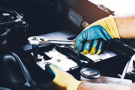 Téléchargez les photos : The Mechanic hand is fasten the bolt of battery Anode with socket wrench - en image libre de droit