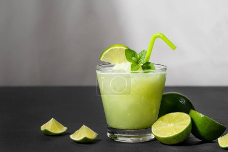 Téléchargez les photos : Jus de cocktail avec citron vert, menthe et glace. Accessoires de boissons de bar sur fond de table noir
. - en image libre de droit
