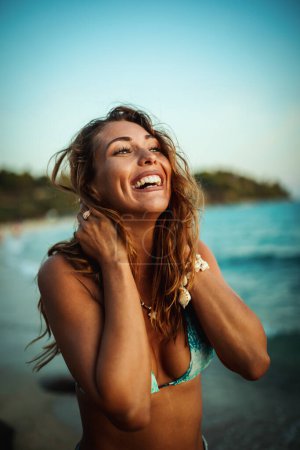 Photo for Portrait of beautiful young woman on beach during her vacation - Royalty Free Image