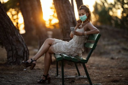 Photo for Portrait of beautiful young woman with medical breath mask on beach during sunset - Royalty Free Image