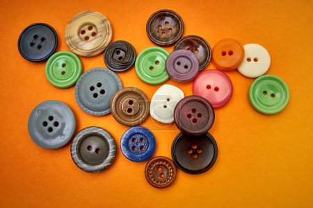 Photo for Buttons sewing on an orange background - Royalty Free Image